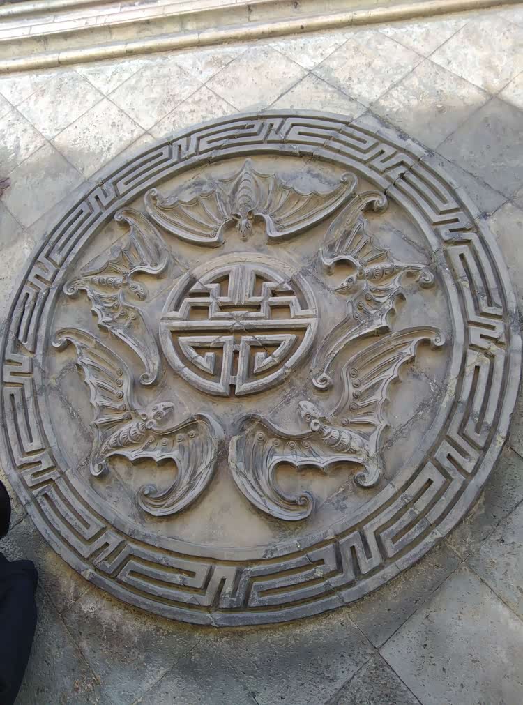 砖雕"五蝠捧寿",正中是"五蝠"大圆盘,左是石与鹤,右为松与鹿.